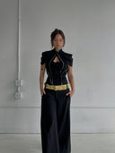 @emmywhereigo wearing the Open Heart Top in Black by Ottolinger, a sculptural black top with cutout detailing and an asymmetrical silhouette, styled with a maxi skirt or tailored bottoms for a fashion-forward evening or editorial-inspired look.